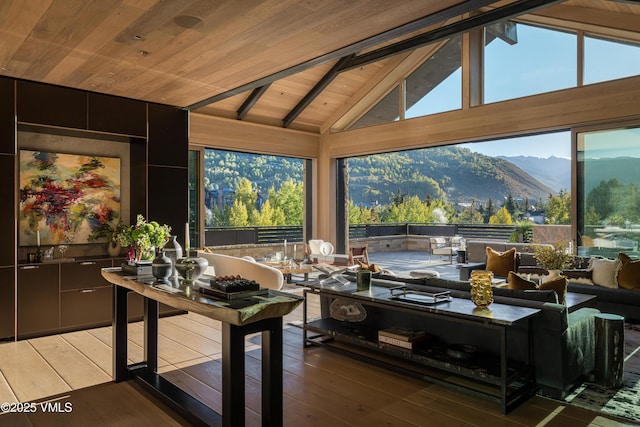 interior space featuring a mountain view, vaulted ceiling with beams, and wooden ceiling