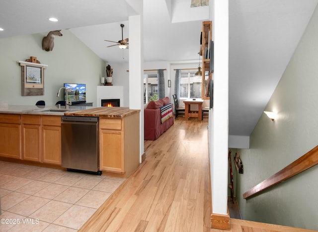 104-2 Quail Cir, Gypsum, CO 81637 - kitchen with stainless steel dishwasher, open floor plan, vaulted ceiling, ceiling fan, and a lit fireplace