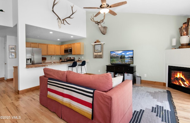 104-2 Quail Cir, Gypsum, CO 81637 - living area with light wood-style flooring, high vaulted ceiling, a ceiling fan, a glass covered fireplace, and recessed lighting