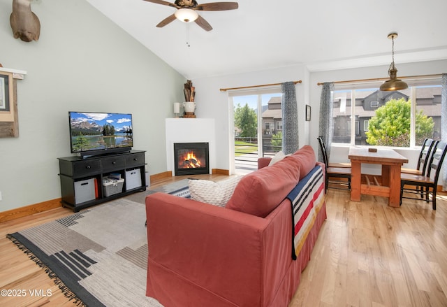 104-2 Quail Cir, Gypsum, CO 81637 - living room with light wood finished floors, a glass covered fireplace, ceiling fan, and vaulted ceiling
