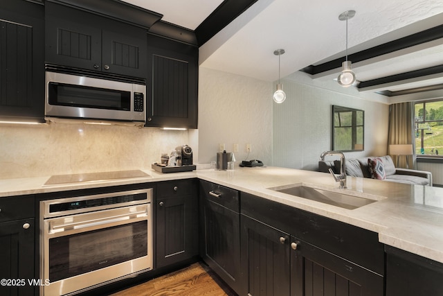 130 Daybreak Rdg Unit 732, Avon, CO 81620 - kitchen with stainless steel appliances, dark cabinetry, a sink, light countertops, and beamed ceiling