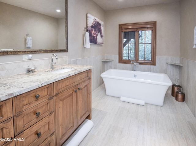 1120 Village Rd Unit 7, Beaver Creek, CO 81620 - bathroom with a soaking tub, a wainscoted wall, and vanity