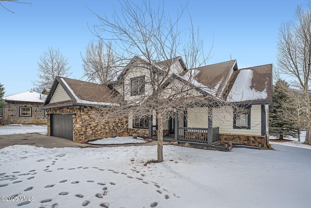 view of front of house with stone siding, roof with shingles, and an attached garage