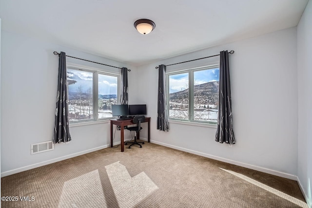 unfurnished office with baseboards, visible vents, and a wealth of natural light