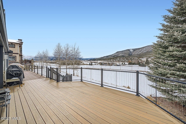 snow covered deck with a mountain view