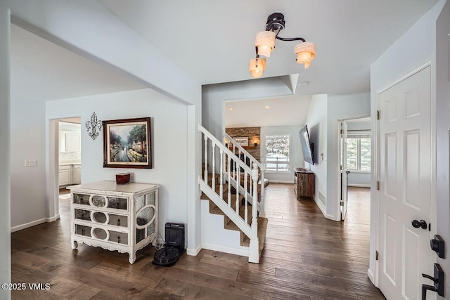 foyer entrance with baseboards, stairway, and dark wood-type flooring