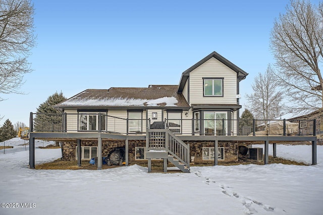 view of front facade with stone siding, stairway, and a wooden deck