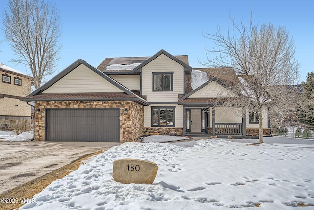 view of front of home featuring stone siding, an attached garage, and driveway