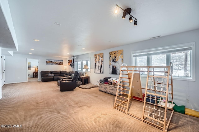 carpeted living area with visible vents and recessed lighting