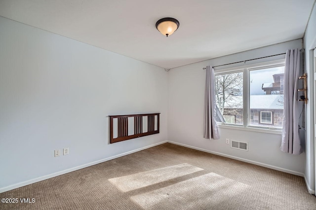 spare room featuring baseboards, visible vents, and carpet flooring