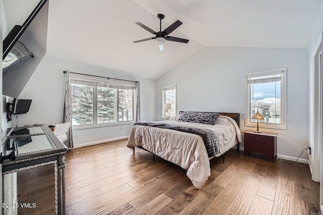 bedroom with ceiling fan, vaulted ceiling, baseboards, and wood finished floors