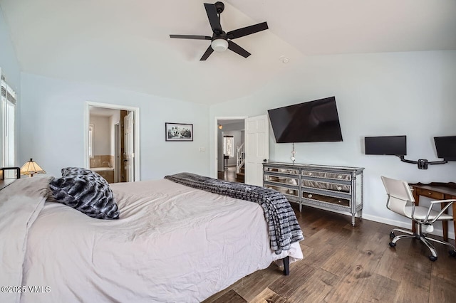 bedroom featuring dark wood-style floors, lofted ceiling, baseboards, and ensuite bathroom