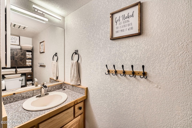 4570 Vail Racquet Club Dr Unit 2-3, Vail, CO 81657 - half bath featuring a textured wall, vanity, and a textured ceiling