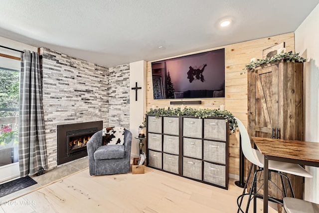 4570 Vail Racquet Club Dr Unit 2-3, Vail, CO 81657 - living room featuring a tiled fireplace, a textured ceiling, and wood finished floors