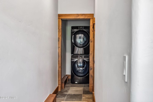 clothes washing area with stacked washing maching and dryer