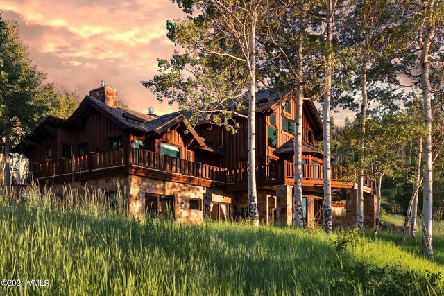 back house at dusk with a balcony