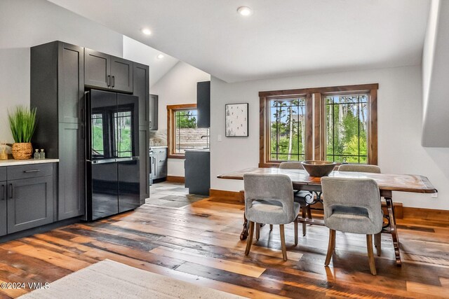 dining area featuring hardwood / wood-style flooring and vaulted ceiling