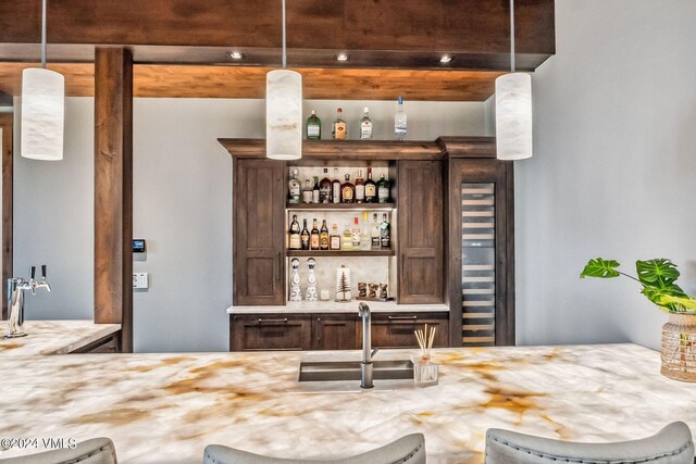 bar with sink and decorative light fixtures