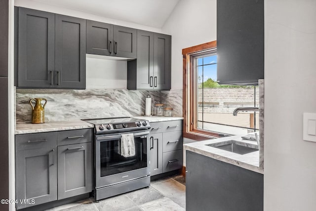 kitchen featuring light stone countertops, sink, decorative backsplash, and stainless steel electric range