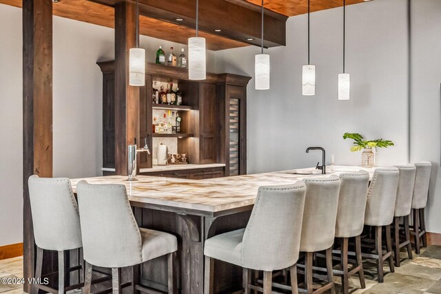 bar with sink, wood counters, and decorative light fixtures