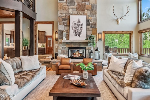 living room with a stone fireplace and a towering ceiling