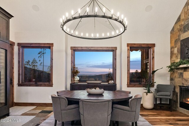 dining room featuring an inviting chandelier, vaulted ceiling, and dark wood-type flooring