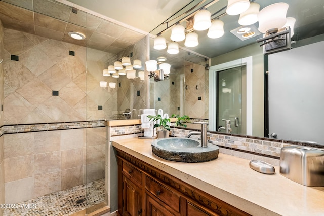 bathroom featuring vanity, backsplash, and walk in shower