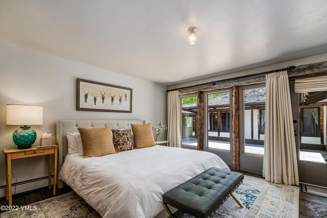 bedroom featuring dark hardwood / wood-style flooring, access to outside, and baseboard heating