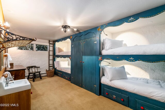 bedroom with light carpet and sink