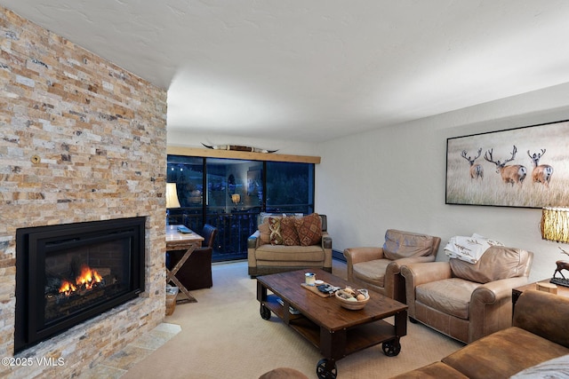 carpeted living room featuring a stone fireplace