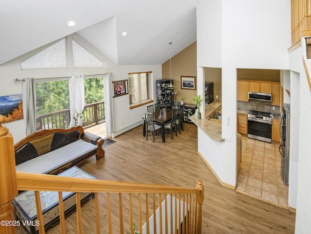 1082 W Wildwood Rd Unit C, Avon, CO 81620 - living area with high vaulted ceiling, light wood-style flooring, a baseboard heating unit, and washer / dryer