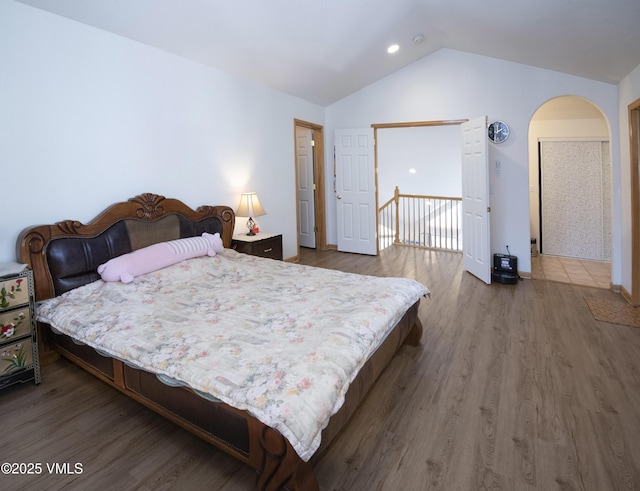 1082 W Wildwood Rd Unit C, Avon, CO 81620 - bedroom featuring vaulted ceiling, arched walkways, and wood finished floors