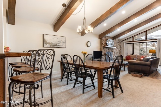 carpeted dining area featuring beam ceiling, an inviting chandelier, and a fireplace