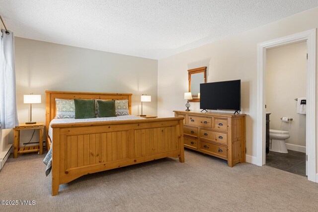 carpeted bedroom with connected bathroom and a textured ceiling