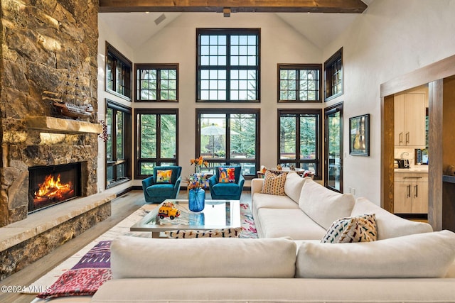 57 Mccoy Creek Dr Unit A, Edwards, CO 81632 - living room featuring wood finished floors, high vaulted ceiling, healthy amount of natural light, beam ceiling, and a stone fireplace