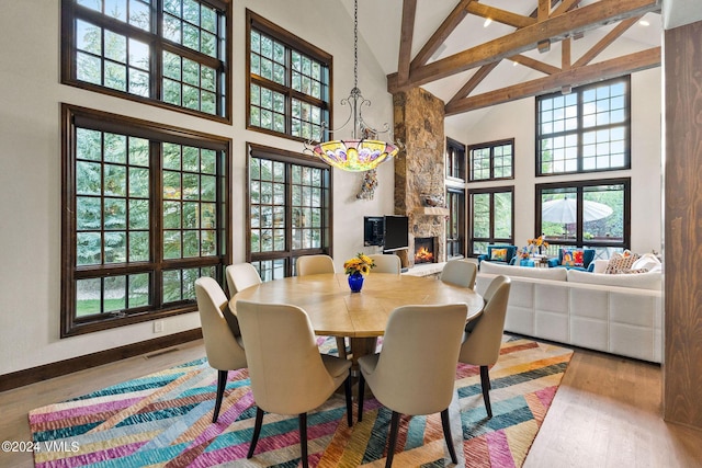 57 Mccoy Creek Dr Unit A, Edwards, CO 81632 - dining room featuring high vaulted ceiling, a stone fireplace, wood finished floors, beamed ceiling, and healthy amount of natural light