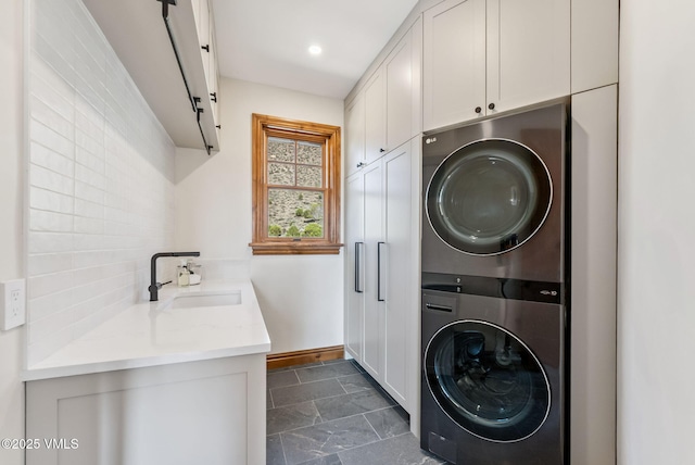 196 Spring Creek Ln, Edwards, CO 81632 - washroom with stacked washer / dryer, cabinet space, dark stone finish flooring, and recessed lighting