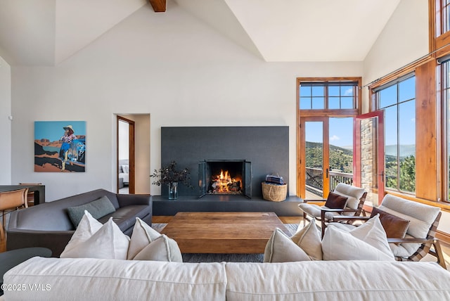 196 Spring Creek Ln, Edwards, CO 81632 - living area featuring high vaulted ceiling, wood finished floors, a lit fireplace, and beam ceiling