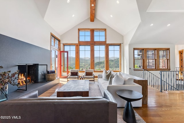 196 Spring Creek Ln, Edwards, CO 81632 - living area featuring a mountain view, high vaulted ceiling, a lit fireplace, wood finished floors, and beamed ceiling