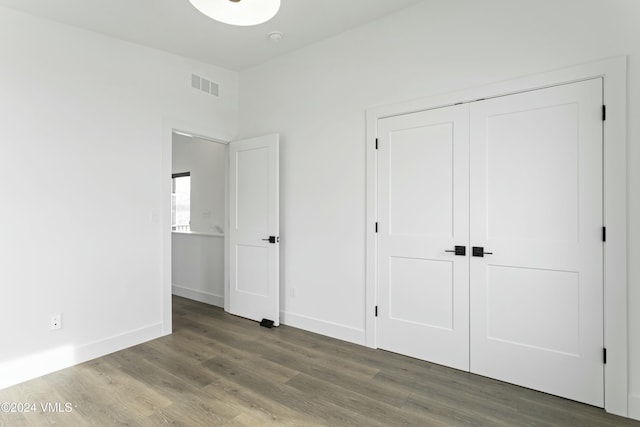 unfurnished bedroom featuring hardwood / wood-style floors and a closet