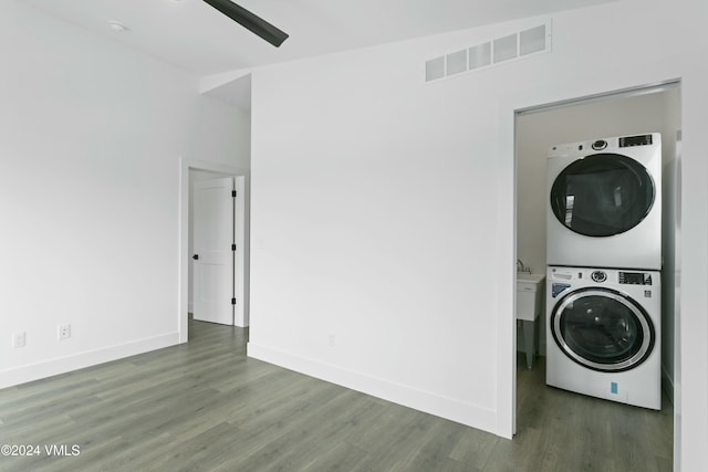 washroom featuring dark wood-type flooring and stacked washer / dryer