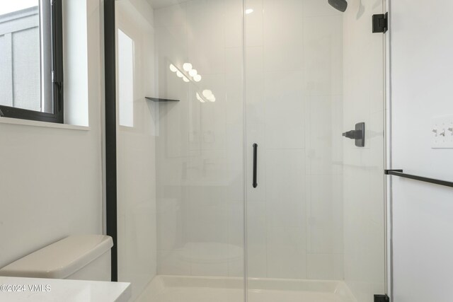 bathroom with walk in shower and toilet