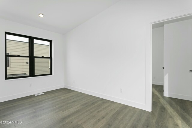 spare room with dark wood-type flooring