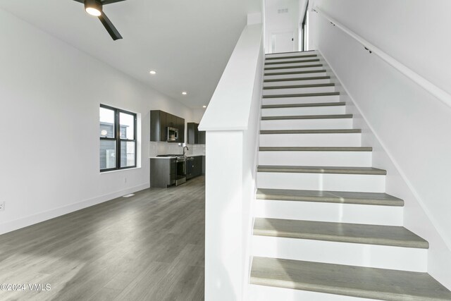 staircase featuring hardwood / wood-style floors and ceiling fan