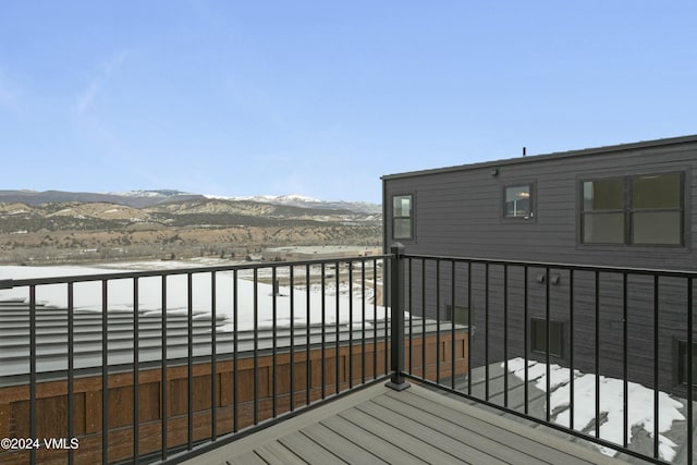 snow covered deck with a mountain view