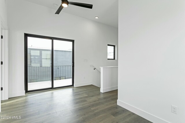 empty room with plenty of natural light, dark hardwood / wood-style floors, and ceiling fan