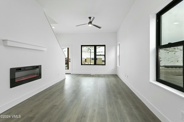 unfurnished living room with ceiling fan and dark hardwood / wood-style flooring