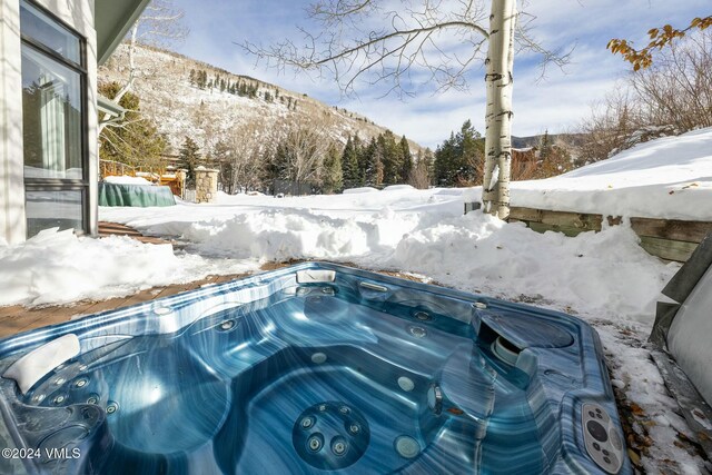 exterior details featuring a hot tub and a mountain view