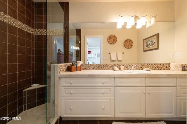 bathroom featuring tasteful backsplash, vanity, and an enclosed shower