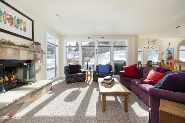 living room with an inviting chandelier, carpet flooring, a wealth of natural light, and a fireplace